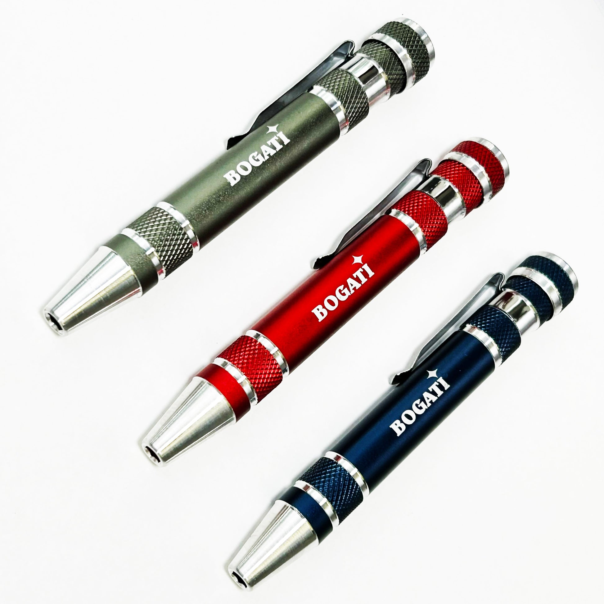 Three BOGATI brand multi-functional screwdriver with textured anodized metal bodies in olive green, red, and navy blue, featuring silver accents and clips, displayed on a clean white background.